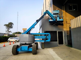 Manlift crane with platform lifting to the roof top of a building