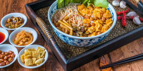 A bowl of Guangxi Liuzhou gourmet snail noodles on a wooden table