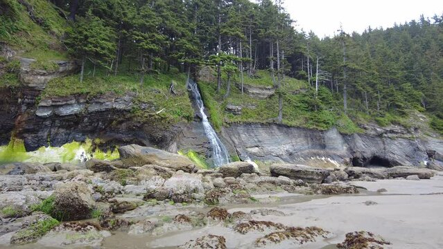 Water runs down Blumenthal Falls onto Short Sand Beach along the Oregon coast. This beautiful area, part of Oswald State Park, offers visitors hiking, surfing, tide pooling, and more.