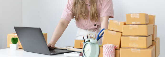 Young woman uses a laptop to chat with customers who come to order product, New young businesses...