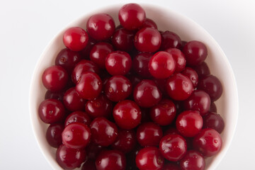 Top view on fresh red cherries in white plate