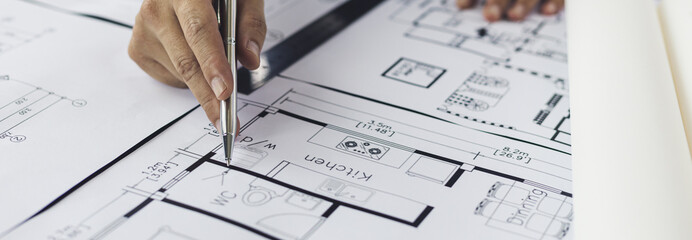 Engineer and Architect concept, Man uses a ruler to measure the floor plan on the blueprint,...