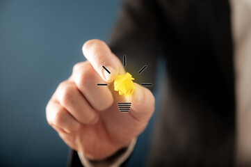 Hand of a businessman creating a light bulb icon a virtual interface