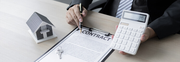 Real estate agent or sales manager talks to clients about the terms of buying a home and collateral...