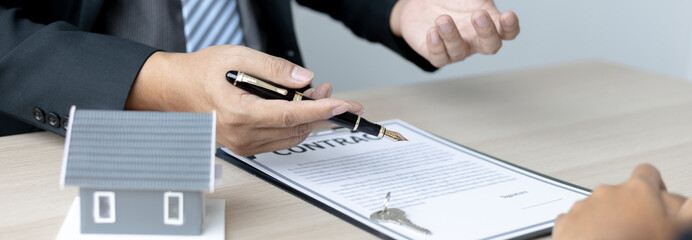 Real estate agent or sales manager talks to clients about the terms of buying a home and collateral...