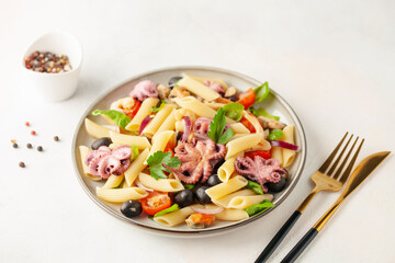 Penne pasta with vegetables and seafood in a plate on the table.