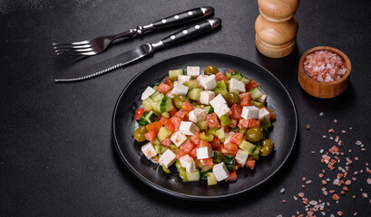 Greek salad with juicy tomatoes, feta cheese, lettuce, green olives, cucumber, red onion and fresh parsley