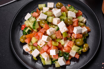 Greek salad with juicy tomatoes, feta cheese, lettuce, green olives, cucumber, red onion and fresh parsley