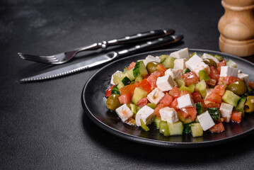 Greek salad with juicy tomatoes, feta cheese, lettuce, green olives, cucumber, red onion and fresh parsley