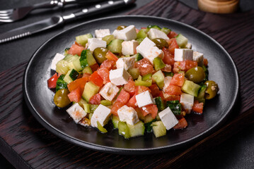 Greek salad with juicy tomatoes, feta cheese, lettuce, green olives, cucumber, red onion and fresh parsley