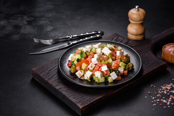 Greek salad with juicy tomatoes, feta cheese, lettuce, green olives, cucumber, red onion and fresh parsley