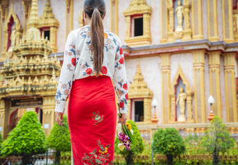 Fototapeta na wymiar Beautiful Asian girl at big Buddhist temple dressed in traditional costume