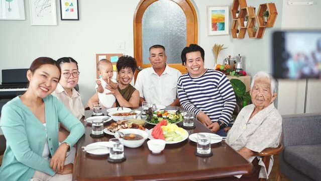 Happy enjoy big Asian family take a photo while dinner together at home