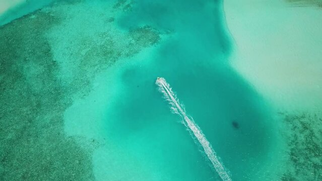 Aerial view of jet ski racing on a crystal clear turquoise water. Enjoying summer vacation in Maldives on a jet ski. Activity in Maldives. High quality 4k footage