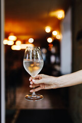 a glass of white wine is held in the hand