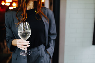 the girl holds a glass of white wine in her hand
