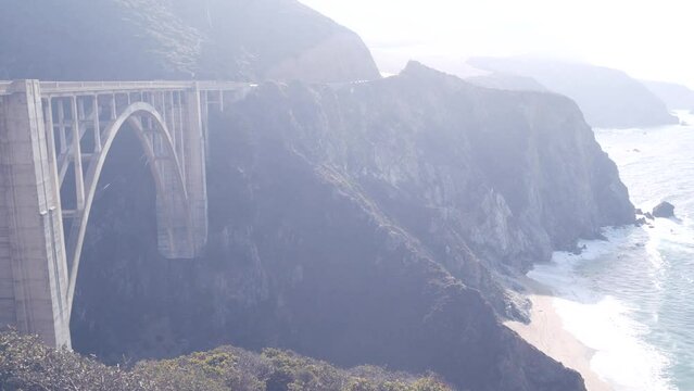 Bixby creek bridge, arch architecture. Pacific coast highway 1 landmark. Historic scenic Cabrillo road. Coastal road trip, journey or travel by ocean. Canyon in foggy weather. California, Big Sur, USA