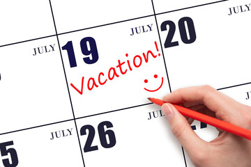 A hand writing a VACATION text and drawing a smiling face on a calendar date 19July. Vacation...