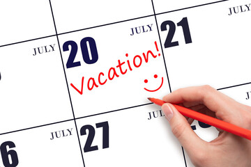 A hand writing a VACATION text and drawing a smiling face on a calendar date 20July. Vacation...