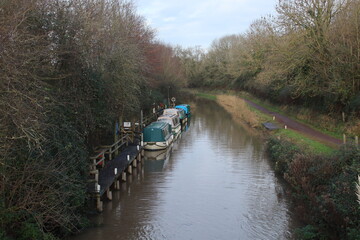 Fototapeta premium Barges moored on the Bridgewater and Taunton Canal in Somerset. It opened in 1827 and linked the River Tone to the River Parrett