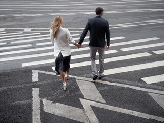 couple in love walks together on a pedestrian crossing, a man and a woman walk in the city, the road