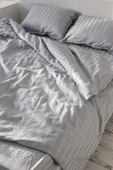 Obraz premium gray linens in sunlight on bed in bedroom