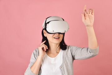 Asian woman using vr glasses, Hand grabbing something from virtual reality headset, Young woman having fun with new experience by vr technology, Studio shot.