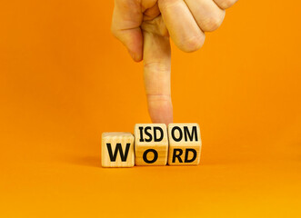 Wisdom word symbol. Concept words Wisdom word on wooden cubes. Businessman hand. Beautiful orange table orange background. Business and wisdom word concept. Copy space.