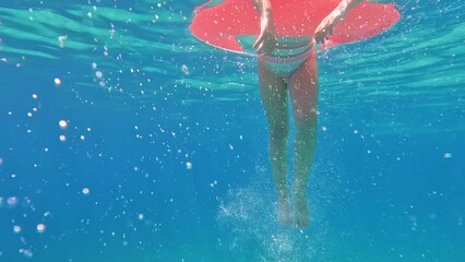 Underwater view of girl floating on inflatable ring. Slow motion 4k.