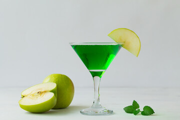 Apple cocktail mixed drink with vodka and apple slice. Apple martini cocktail on the white background. Homemade Green Alcoholic drinks in martini glasses with apple slice. copy space.