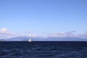 Lake Taupo with sailboat. View to snowy mount Tongariro