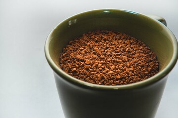 A cup full of coffee powder. Cup full of coffee on a white background.