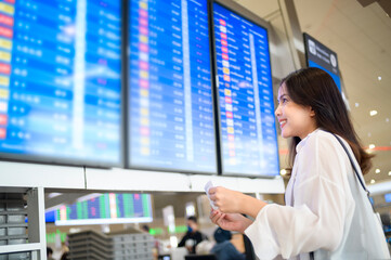 Young female traveler carrying suitcases at the International airport, travel, holidays and journey concept..