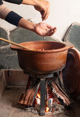 cocinando con leña en olla de barro tradicional Argentina