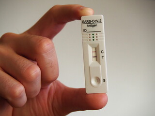 Coronavirus positive antigen test result in man's hand showing Covid 19 disease in pandemic times