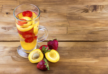 Drink with fresh fruit apricots and strawberries in a glass.