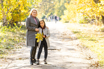 happy family: mother and child little daughter play on autumn walk in nature outdoors