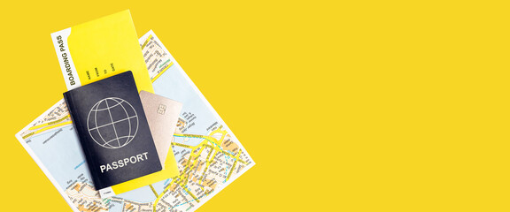 Banner with passport, boarding pass, credit card and tourist map on yellow background. Essential travel items. Tourism concept. Copy space. High quality photo