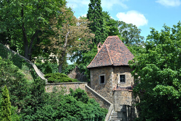 Fototapeta na wymiar zdjęcie architektury przedstawiające basztę obronną z fragmentem murów w parku