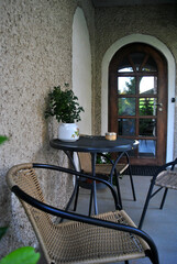 Zdjęcie przedstawiające meble ogrodowe ustawione na tarasie przed wejściem - obrazy, fototapety, plakaty