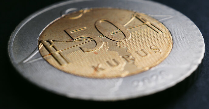 Translation: 50 kurus. Turkish coin of 50 kuruş lies on a dark surface close-up. National currency of Turkey. Horizontal stories for news about economy or finance. Bosphorus Bridge. Macro