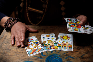Close up of tarot cards and woman hands using them.