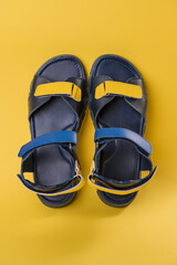 Black leather summer sandals with blue and yellow Velcro. Patriot shoes