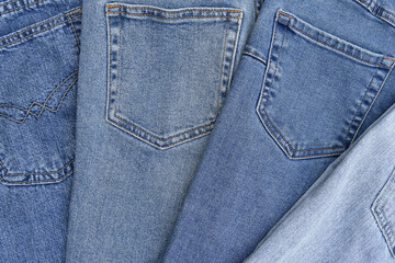 Fototapeta premium Lots of jeans pants in a stack. Denim background.