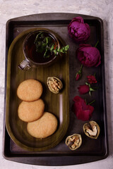 Still life. Toning. Homemade cookies, walnuts, flowers, fresh mint tea. View from above.