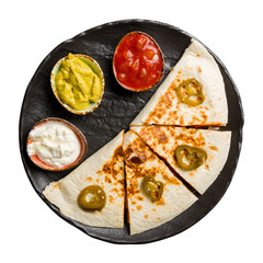 Quesadilla with chicken and sauces on black plate