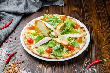 Pizza Caesar on plate on wooden table