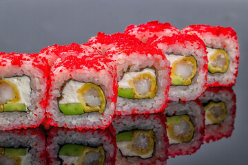 California roll with shrimp on black with reflection