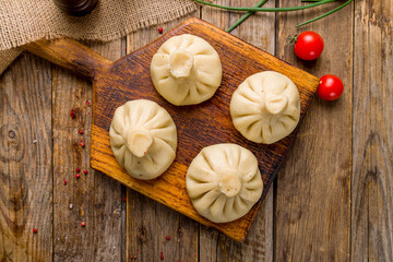Khinkali with lamb on board on old wooden table top view