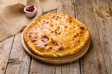Ossetian pie with cherry on old wooden table